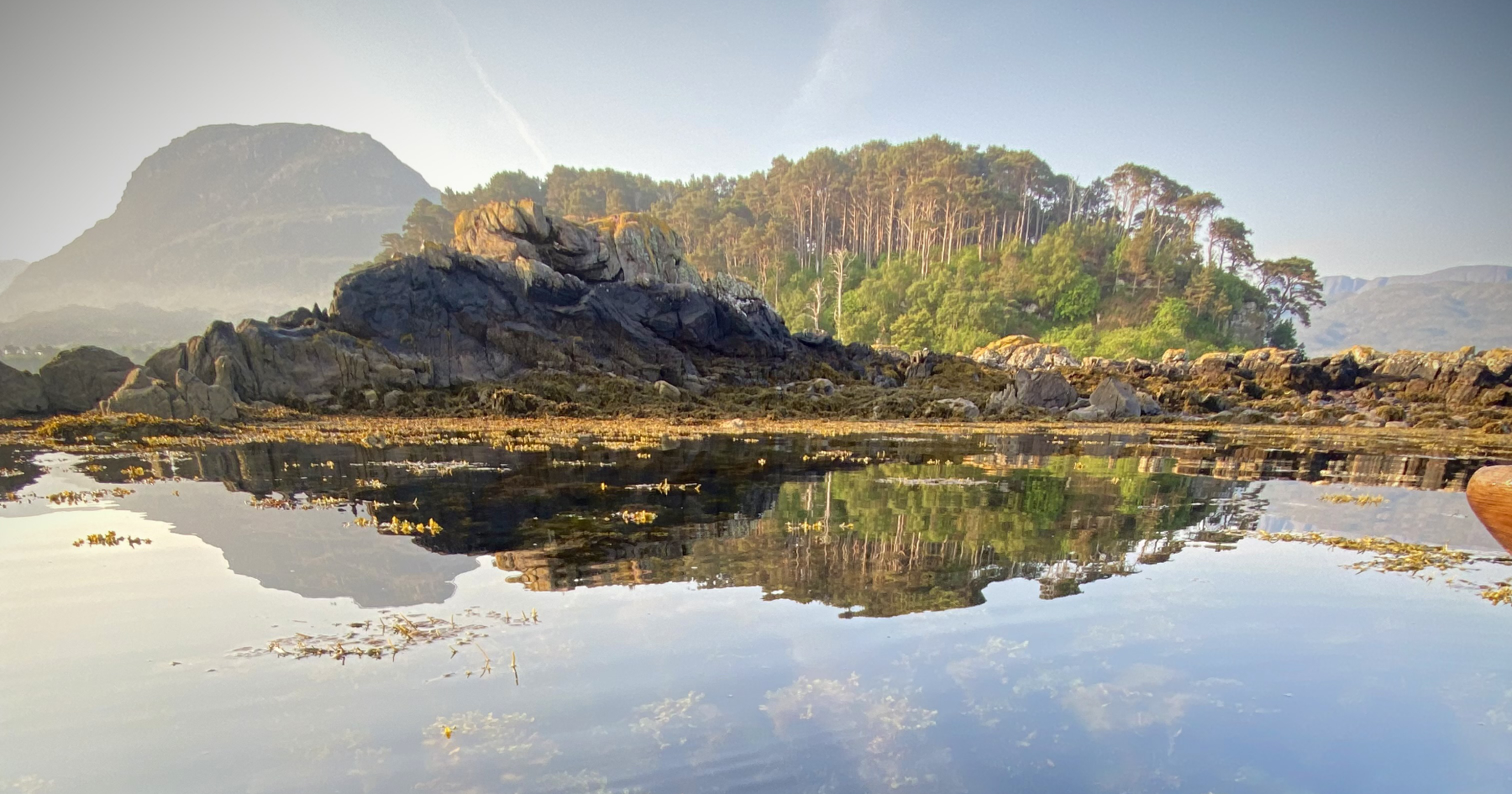 Scenic landscape with mountains and calm water reflection.